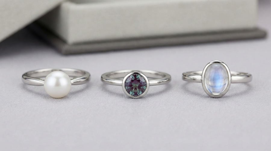 June birthstone ring designs: classic pearl in white gold, modern alexandrite solitaire, and protective bezel-set moonstone