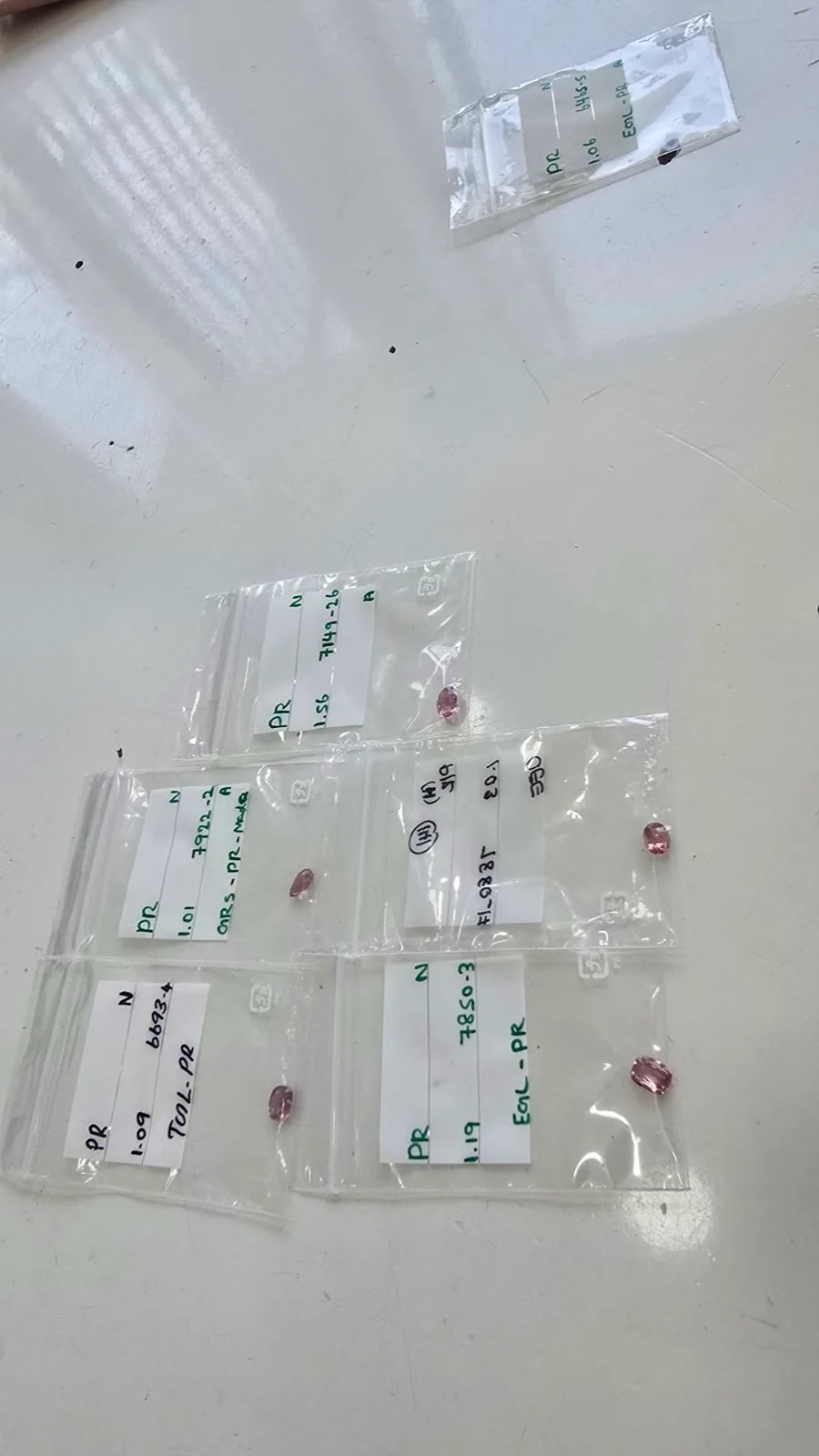 Labeled sapphire parcels in baggies with handwritten lab and weight references, the boring way to verify a stone