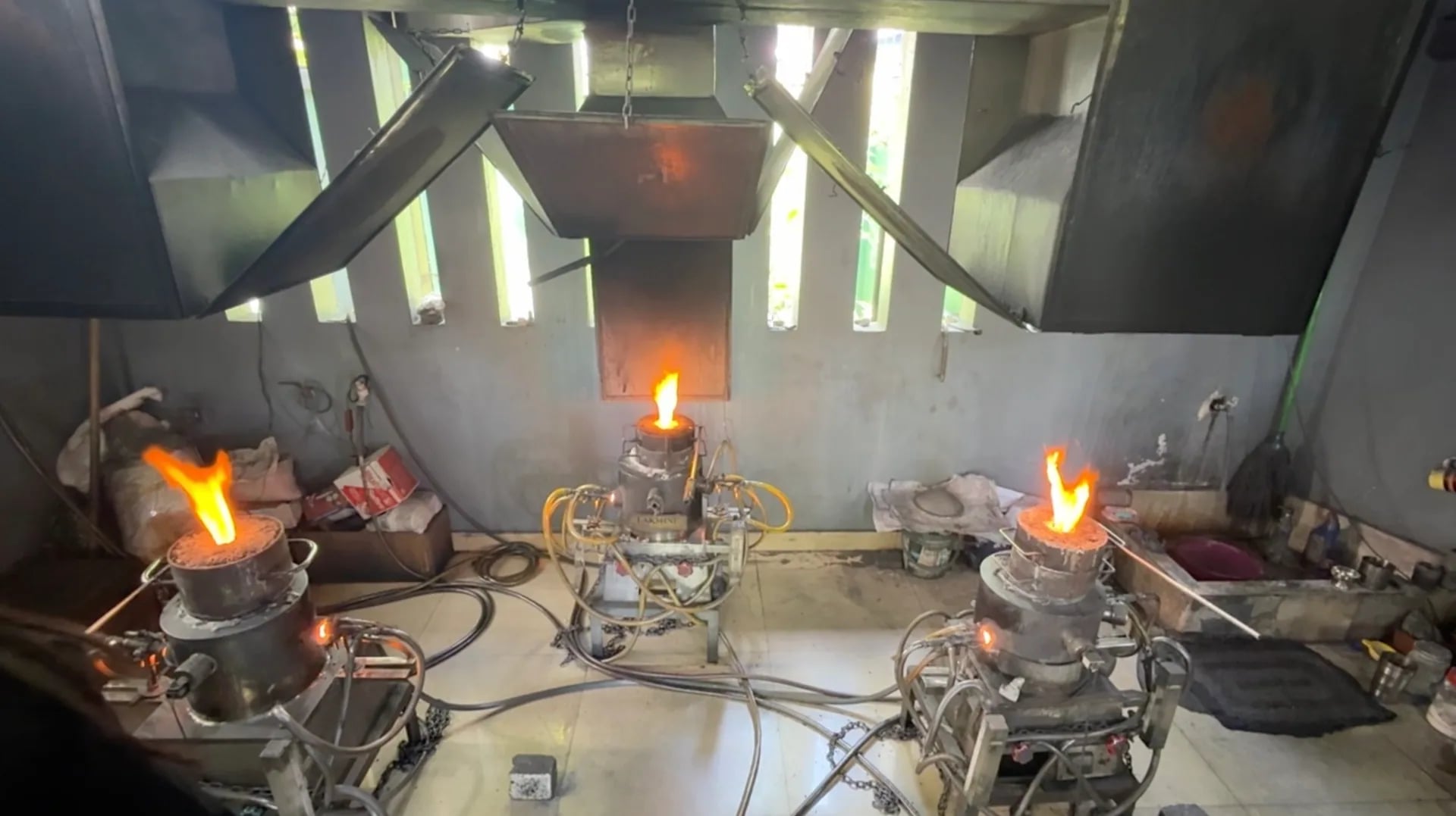 Real sapphire heat treatment furnaces with open flames in a workshop in Sri Lanka, where geuda rough becomes blue sapphire